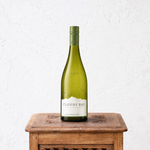 Cloudy Bay wine bottle on a wooden table with a white background