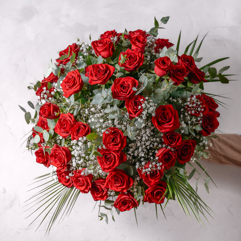Close up of fifty hand-tied red roses with gypsophila in the Fifty Red Roses bouquet