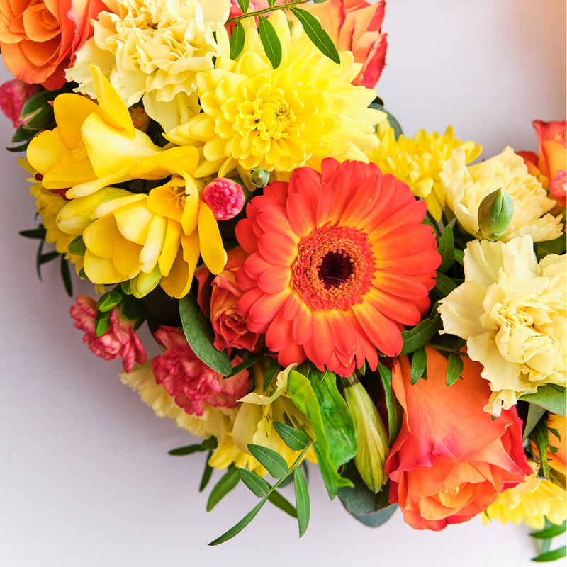 Up-close Orange wreath of roses and gerberas for graveside tribute Ireland