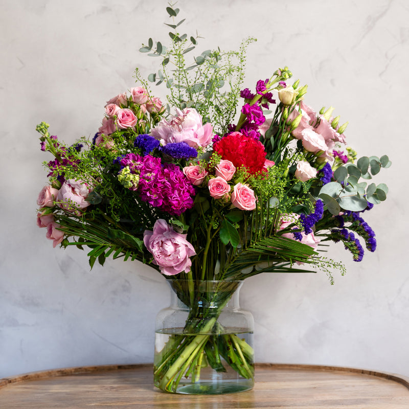 Close up of Peony Perfection bouquet showing blush peony roses in full bloom with lisianthus and statice in a luxury summer arrangement