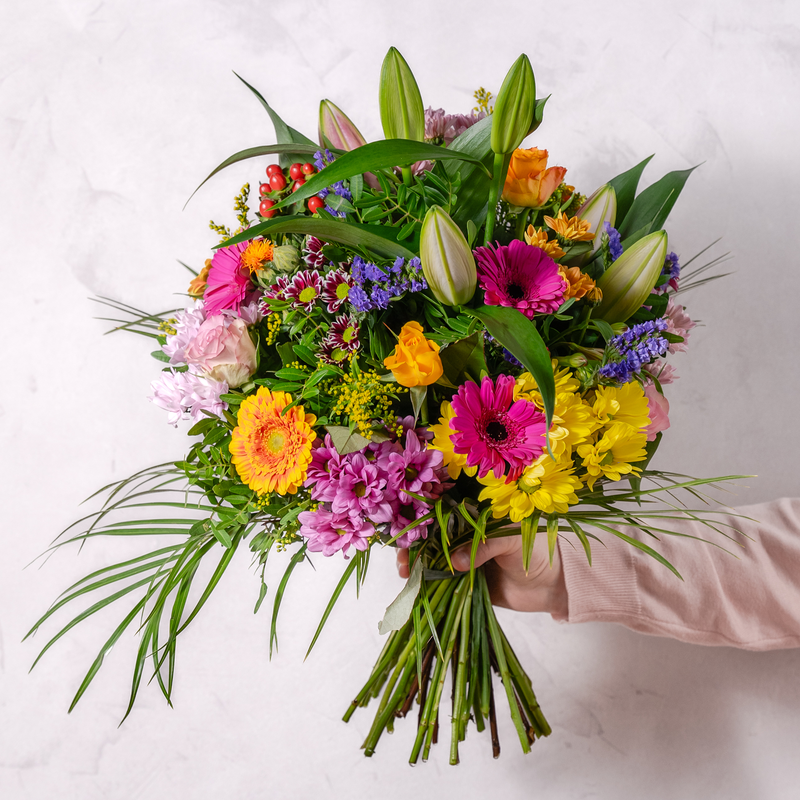 Close up of Surprise bouquet showing mini gerbera, spray chrysanthemums and hypericum in a vibrant colourful arrangement