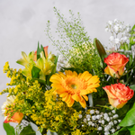 Close up of You're So Golden bouquet showing yellow roses, gerbera and lilies with gypsophilia and eucalyptus