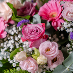 Close up of Blushing Beauty bouquet showing premium Avalanche roses and Candlelight roses with pink waxflowers in a luxury arrangement